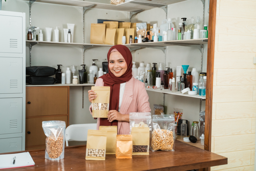 Female small business owner displaying packaged food products in her shop